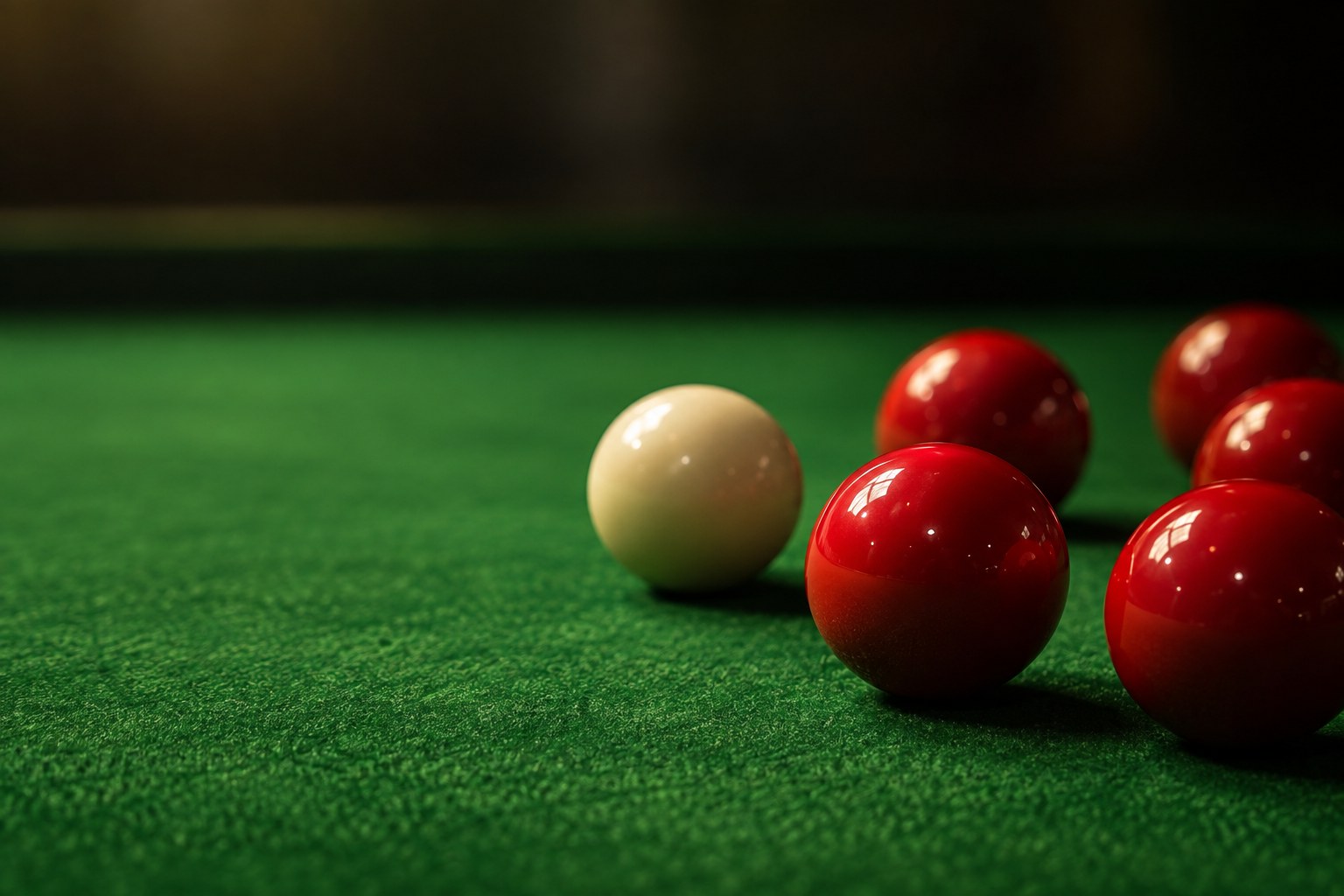 Red snooker balls and a cue ball on green baize